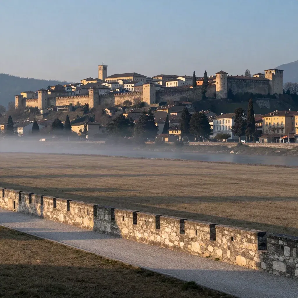 Trento e la fortezza sul colle sopra la valle dell’Adige al tramonto, con nebbia morbida.